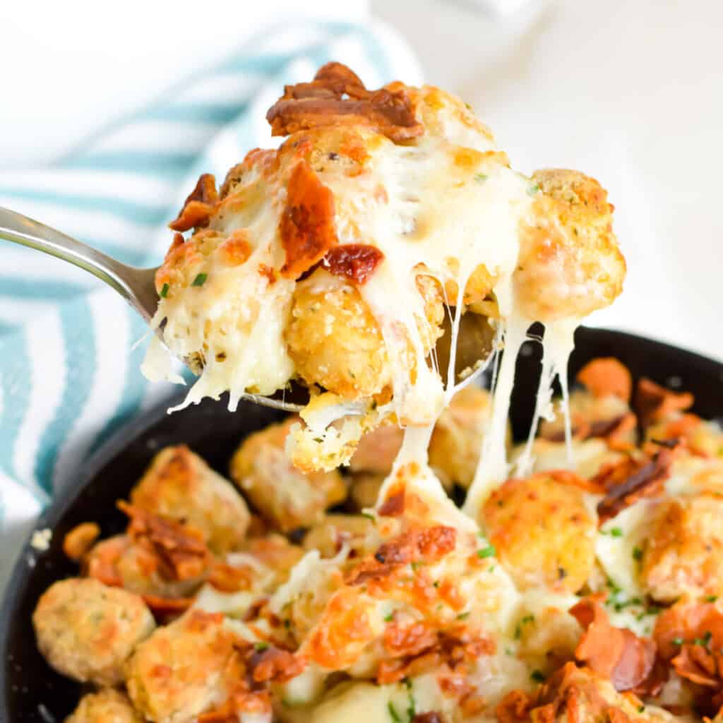 Spoonful of tater tots with cheese and bacon.