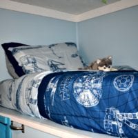 Blue Star Wars bedding on a top bunk bed.