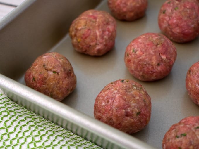 close up of meatballs on a tray ready to be baked