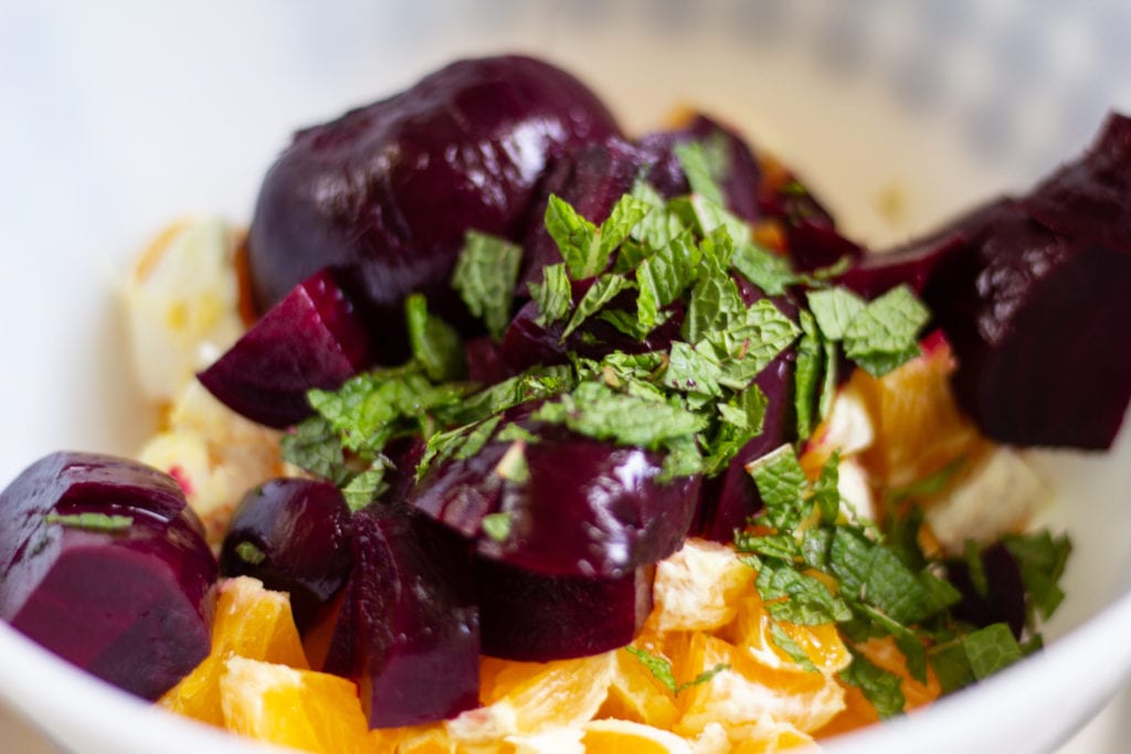 Roasted beets, oranges, and mint in bowl.
