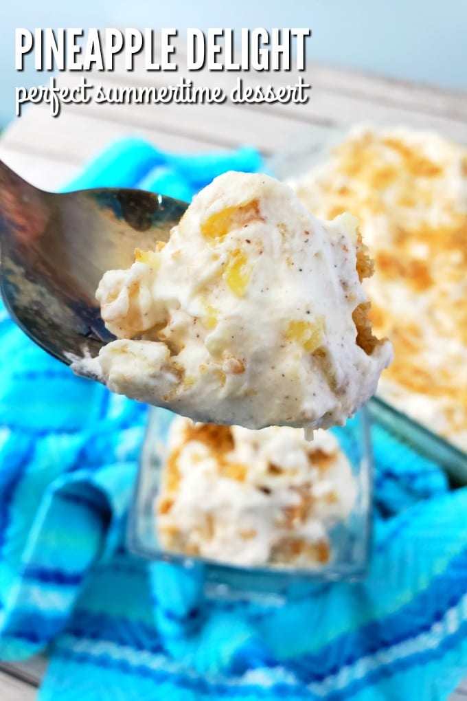 A spoonful of pineapple delight dessert in the foreground with a multi-hued blue towel and a dish of the dessert in the background.