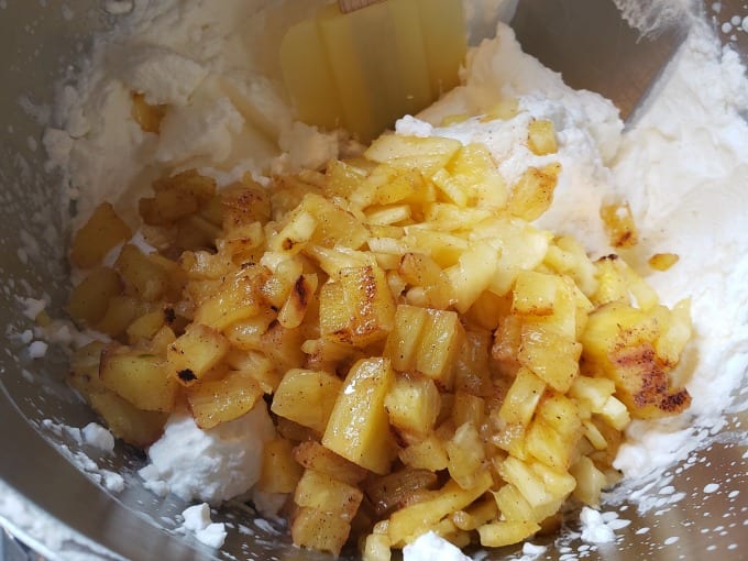 Pineapple and whipped cream in a mixing bowl.