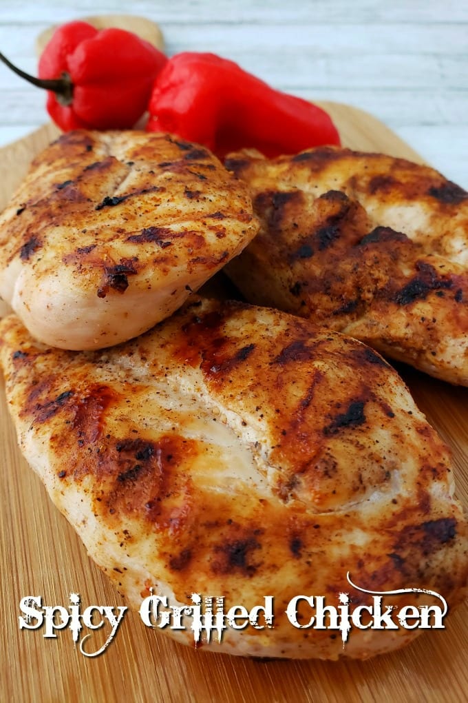 Grilled Chicken on a small cutting board with a couple of habanero peppers