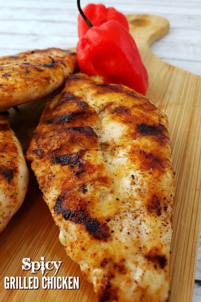 Grilled Chicken on a small cutting board with a couple of habanero peppers