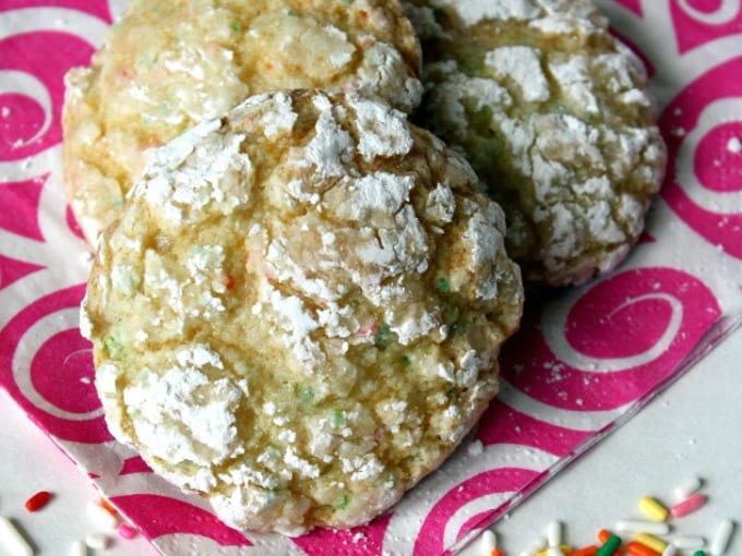 A pile of funfetti crinkle cookies on a pink and white napkins