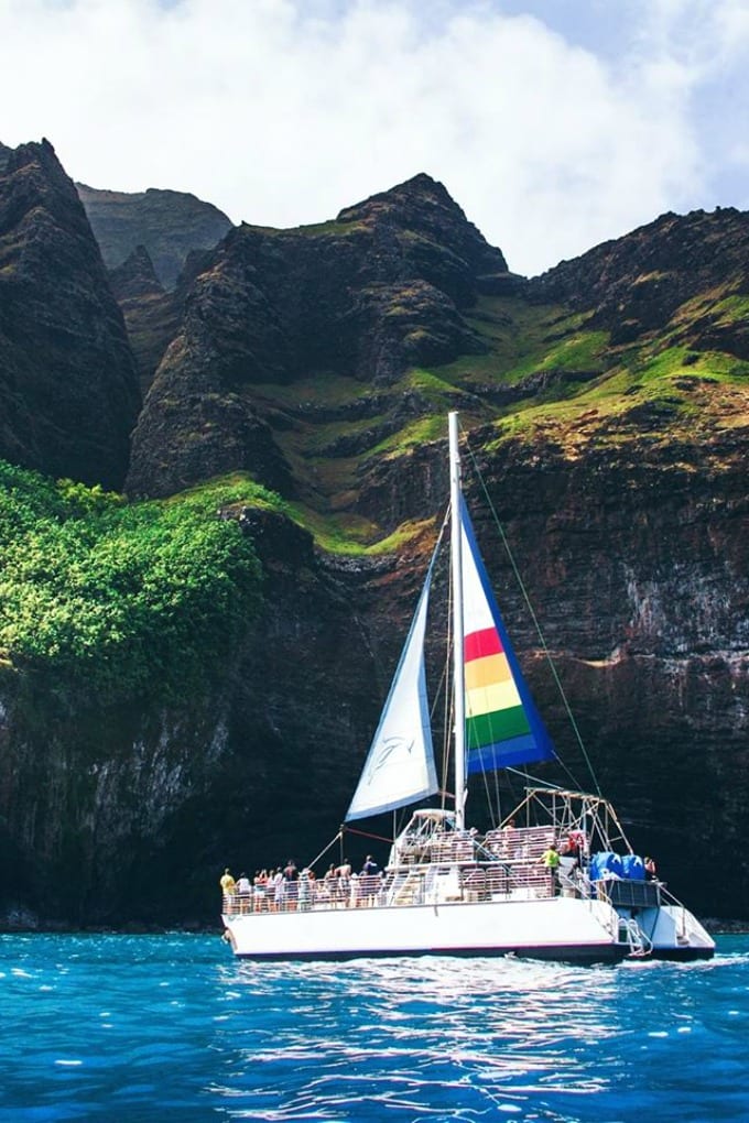 A catamaran sails along the Na Pali Coast during a Kauai Sunset Cruise