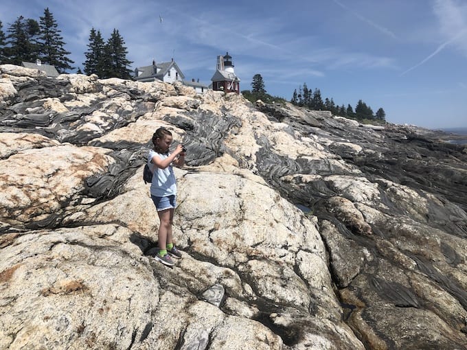 Child at Lighthouse on rocks.
