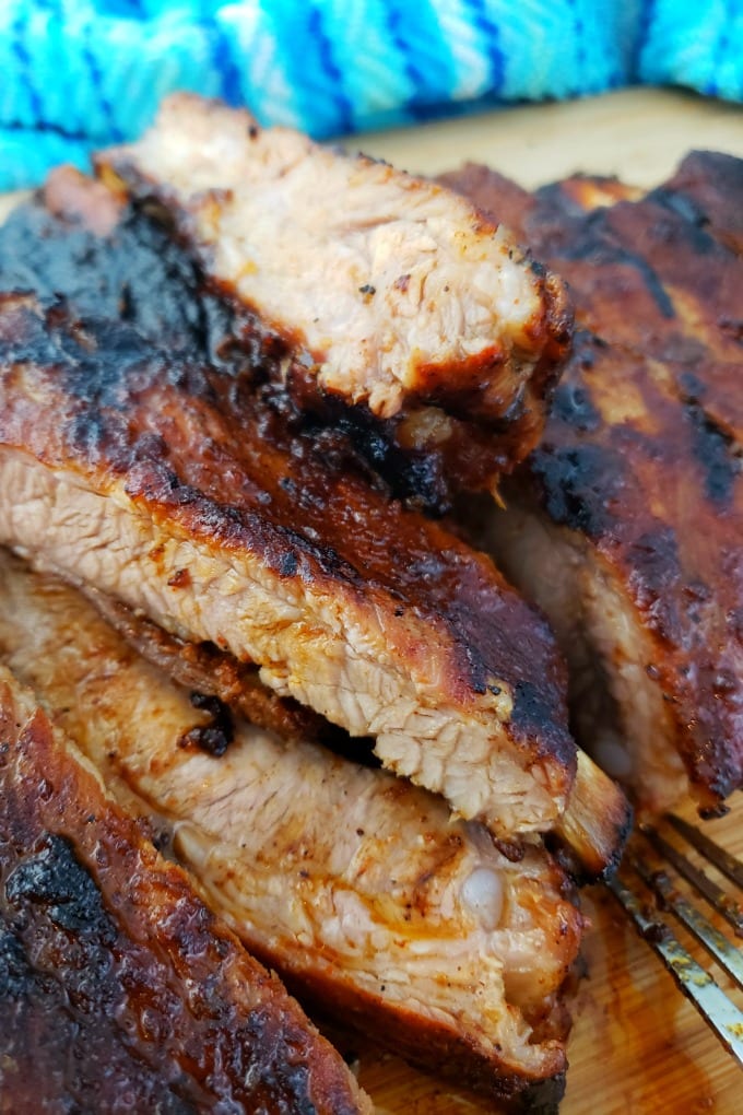 A pile of St. Louis Style Ribs on a cutting board.