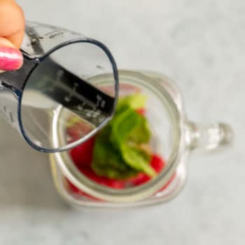 Lime juice added to mint and raspberries