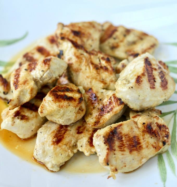 Close up image of grilled chicken on a white plate.