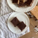 nanaimo bars on white plate with cloth napkin wood table