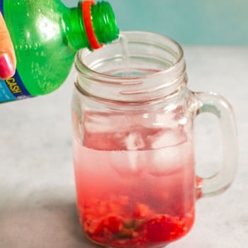 Lime soda being added to the the raspberry mojito glass