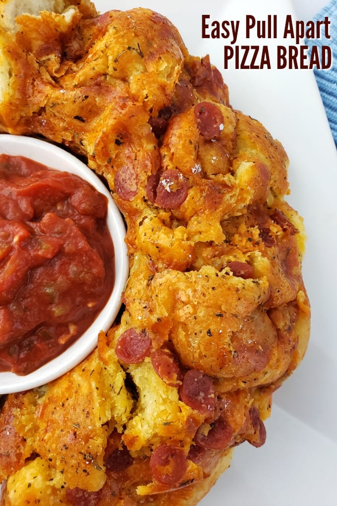 Close up of Pull Apart Pizza Bead on white plate next to a ramekin of marinara sauce.