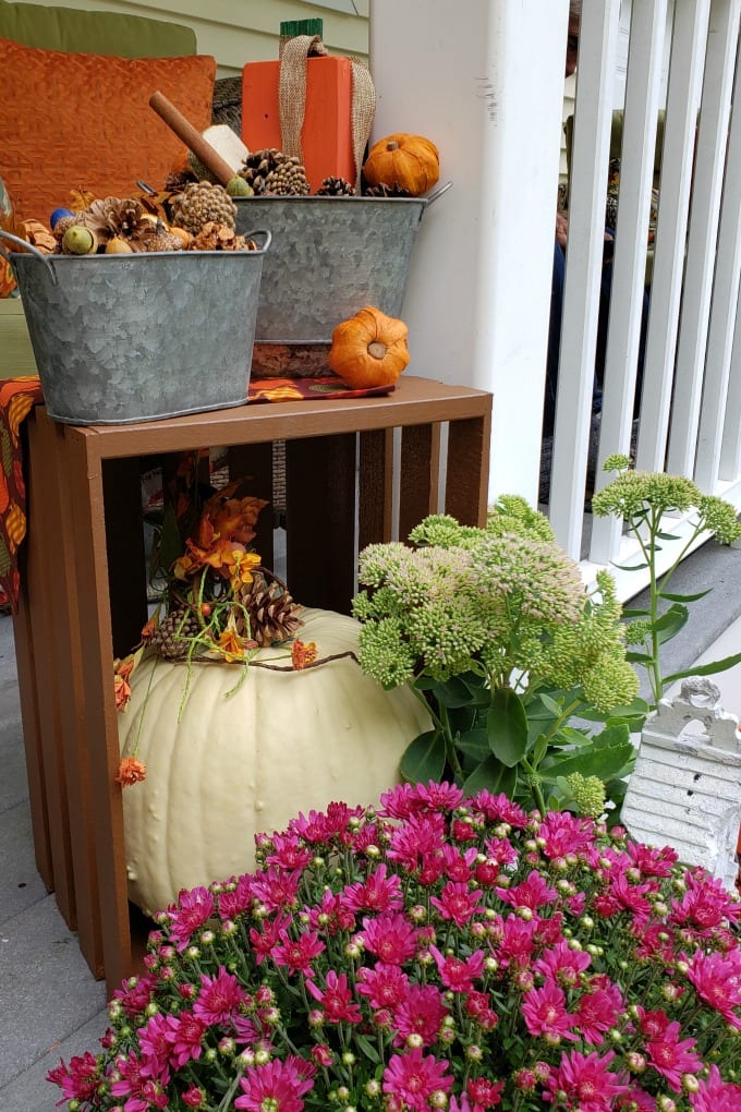 Fall Porch Decorating Ideas - a porch and front door decorated for Fall with colorful mums, pumpkins and other decorations.
