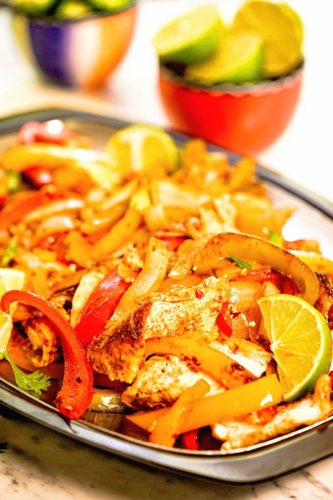 Chicken Fajitas on platter with limes.