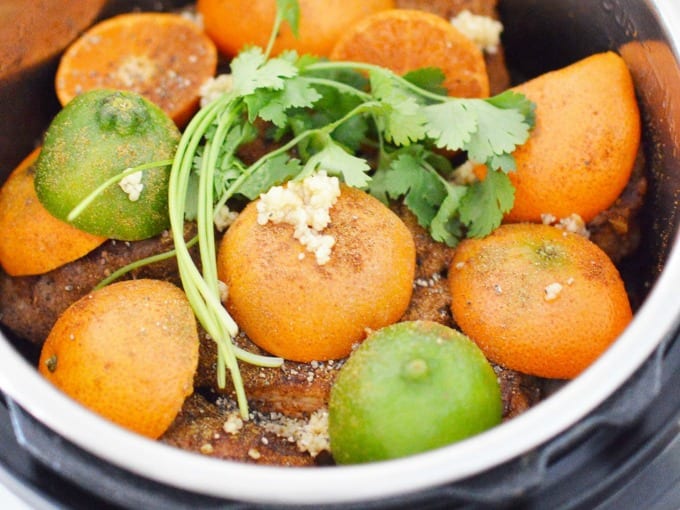 halved clementines and limes with cilantro and garlic on in an instant pot