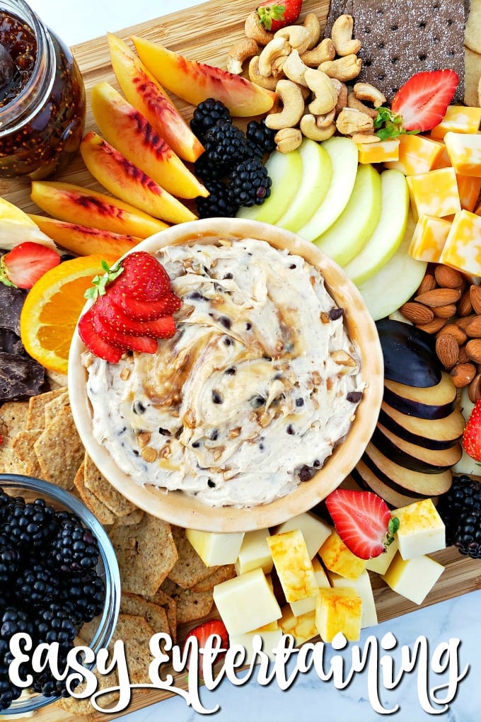 Top down view of a fruit cheese platter with a variety of items to choose from such as sliced fruits and berries, nuts, and cheeses.