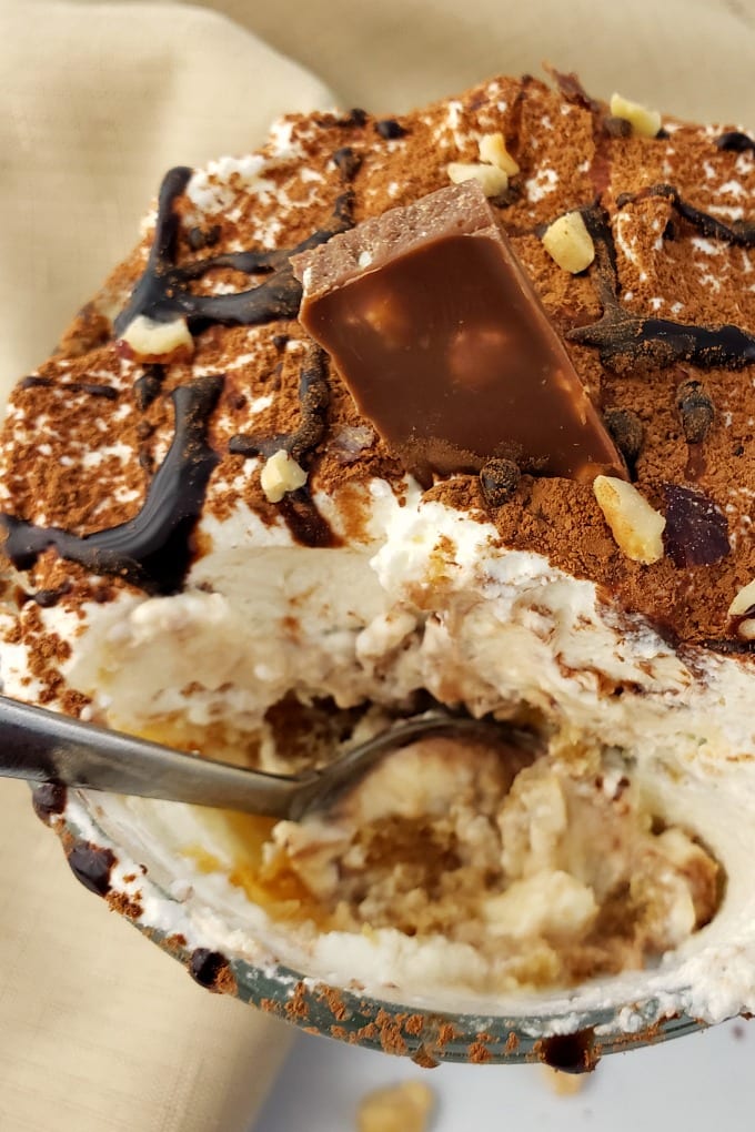 Close up of a spoonful of tiramisu cup dessert.