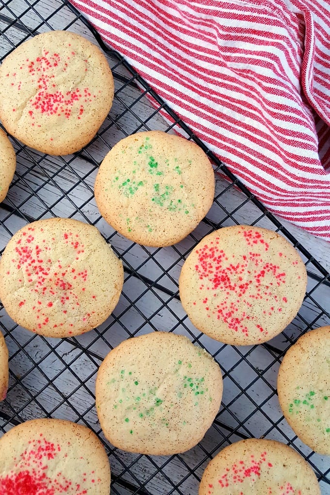 A cooling rack with Christmas snickerdoodles and a red and white towel.