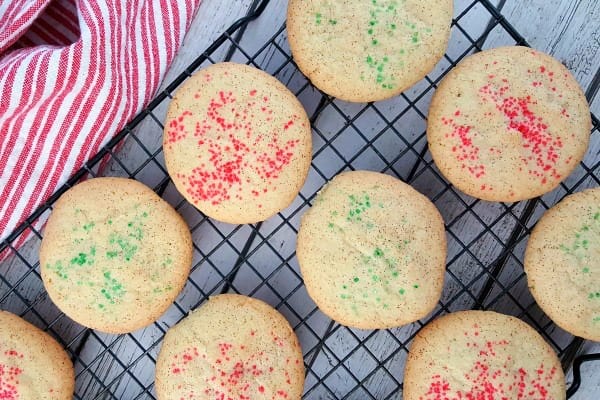 A cooling rack with Christmas snickerdoodles and a red and white towel.
