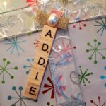 Scrabble tile ornament on top of a gift.