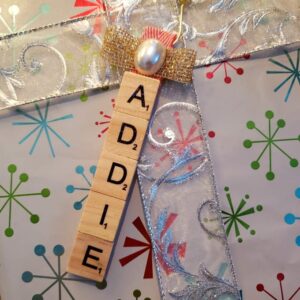 Scrabble tile ornament on top of a gift.