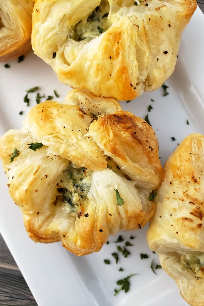 Golden brown Spinach Puff Pastry Cups on a white serving tray.