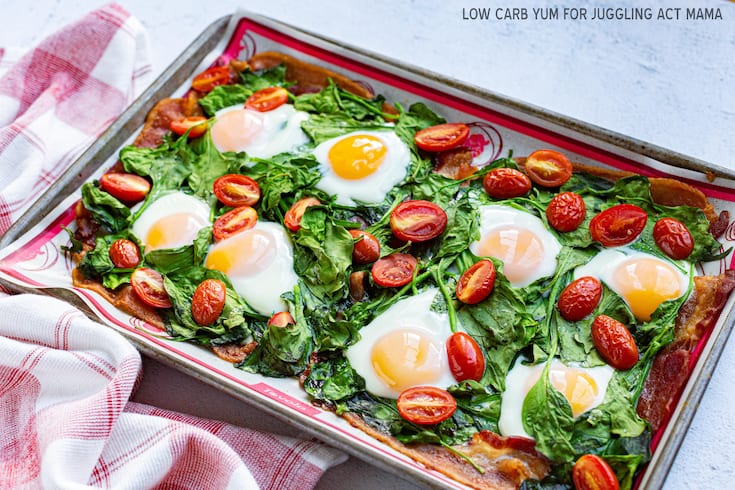 Sheet Pan Eggs and Bacon with tomatoes and spinach opn a baking sheet.