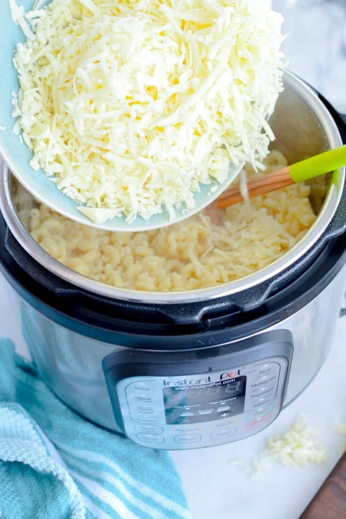 A bowl of shredded cheese hovering over an Instant Pot.