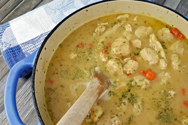Close up of Chicken and Dumplings with Biscuits in a dutch oven.