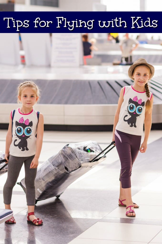 Two girls in an airport with luggage - Tips for Flying with Kids