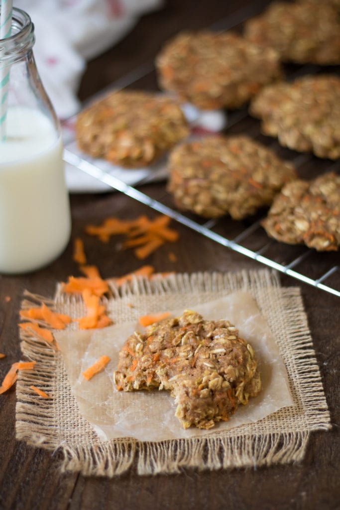 Carrot Cake Cookie on a burlap coaster, next to a cooling rack filled with more.