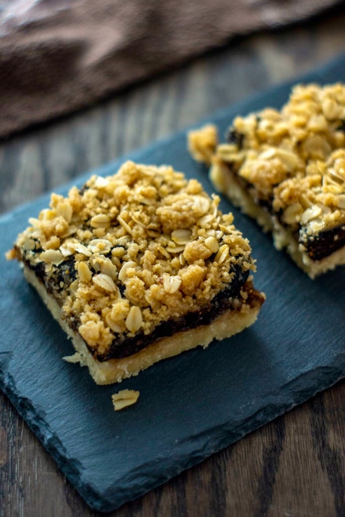Close up image of an oatmeal fig bar on a slate platter.
