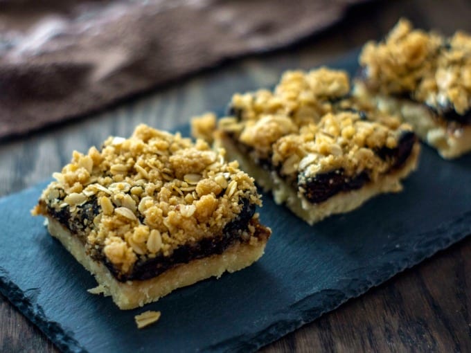 Close up image of oatmeal fig bars on a slate platter. 