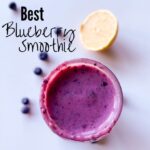 Top of jar with blueberry smoothie, lemons and blueberries around