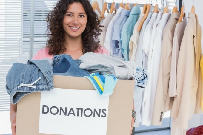 Declutter Challenge - woman holding box of clothes to donate.
Download the 30 day declutter calendar.