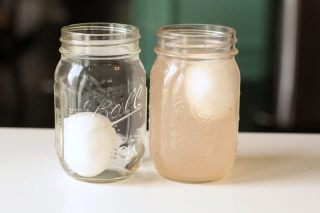 Two glass mason jars willed with liquid and eggs, in the Egg Sink or Float Experiment from Kindergarten Worksheets and Games.