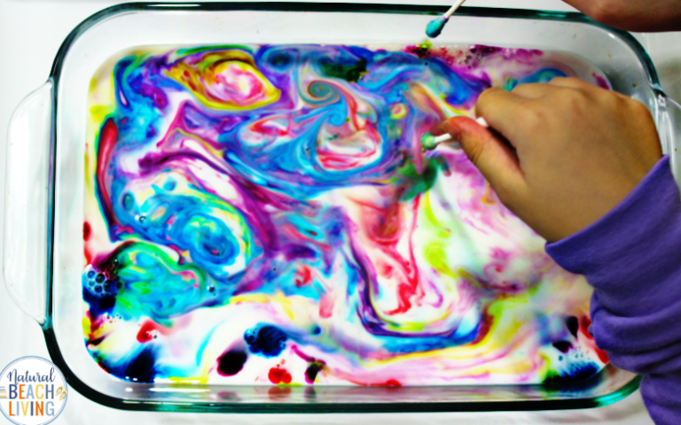 Child swirling food coloring in milk.