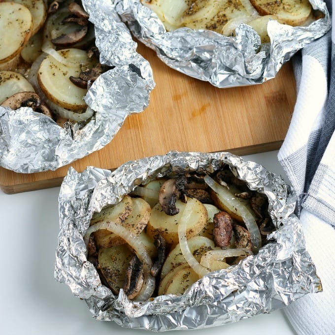 foil pouches of seasoned sliced russet potatoes, thinly sliced yellow onion and mushrooms