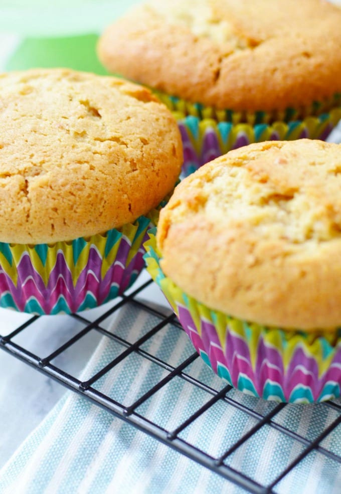Easy vanilla cupcakes on a cooling rack waiting to be frosted.