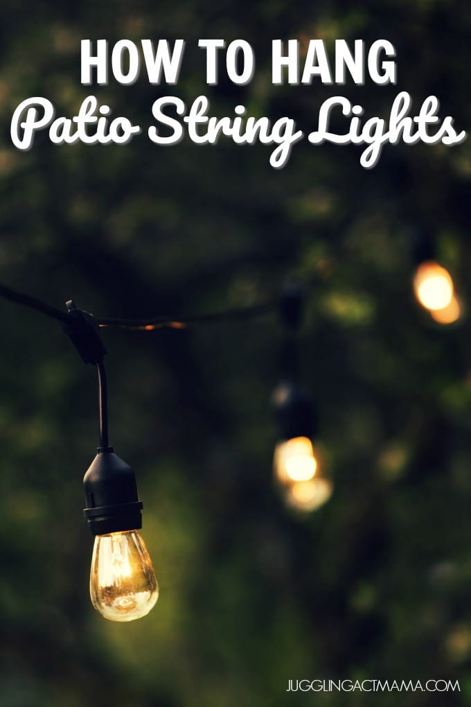 Close up of outdoor string lights hanging in a backyard.