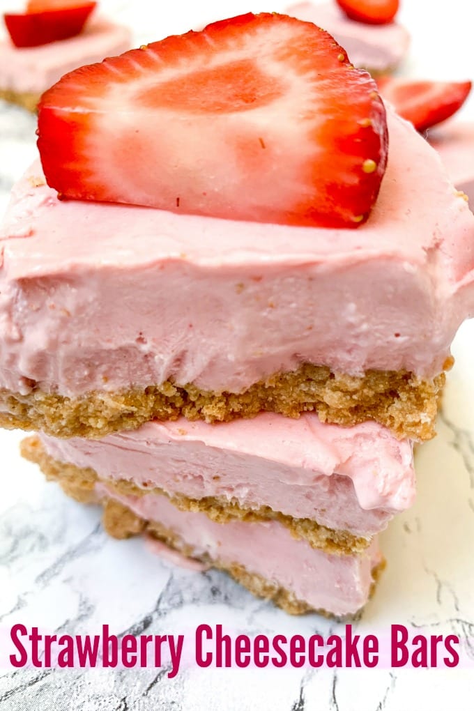 No Bake Strawberry Cheesecake Bars stacked on a marble counter top.