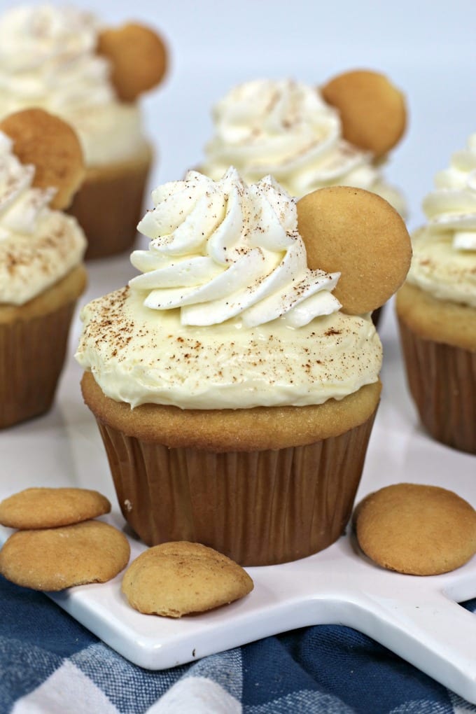 Close up image of a banana pudding cupcake on a white platter surrounded by Nilla wafers.