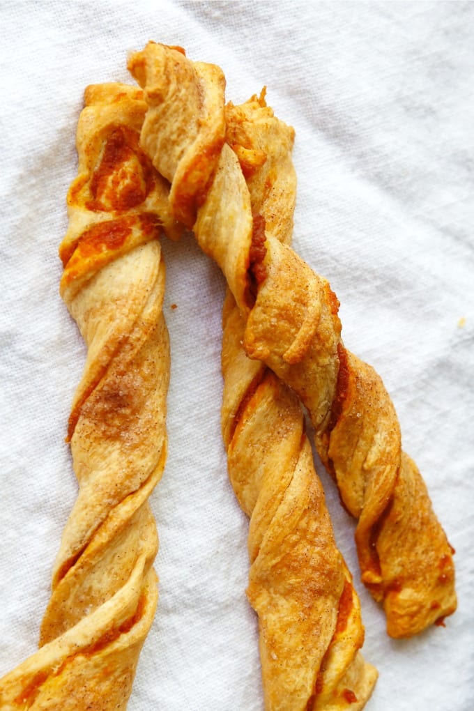 Pumpkin spice puff pastry twists on a clean white towel.