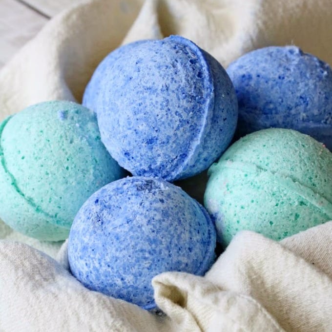 Blue and turqouise bath bombs nestled in a towel.