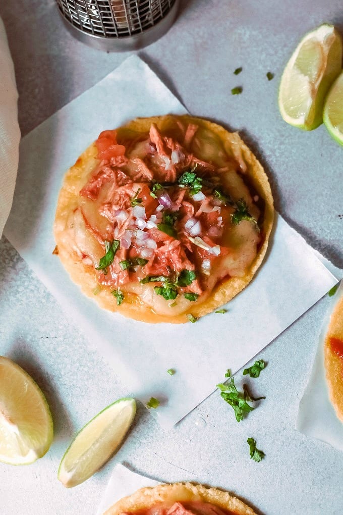 BBQ Chicken Tostada with lime wedges.