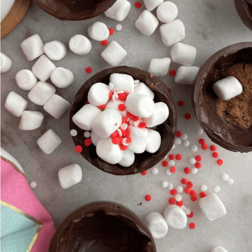 Top down image of a hot chocolate bomb filled with marshmallows and sprinkles.