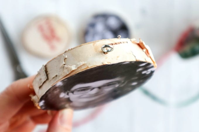 Close up of how to add a hook onto a wood slice ornament