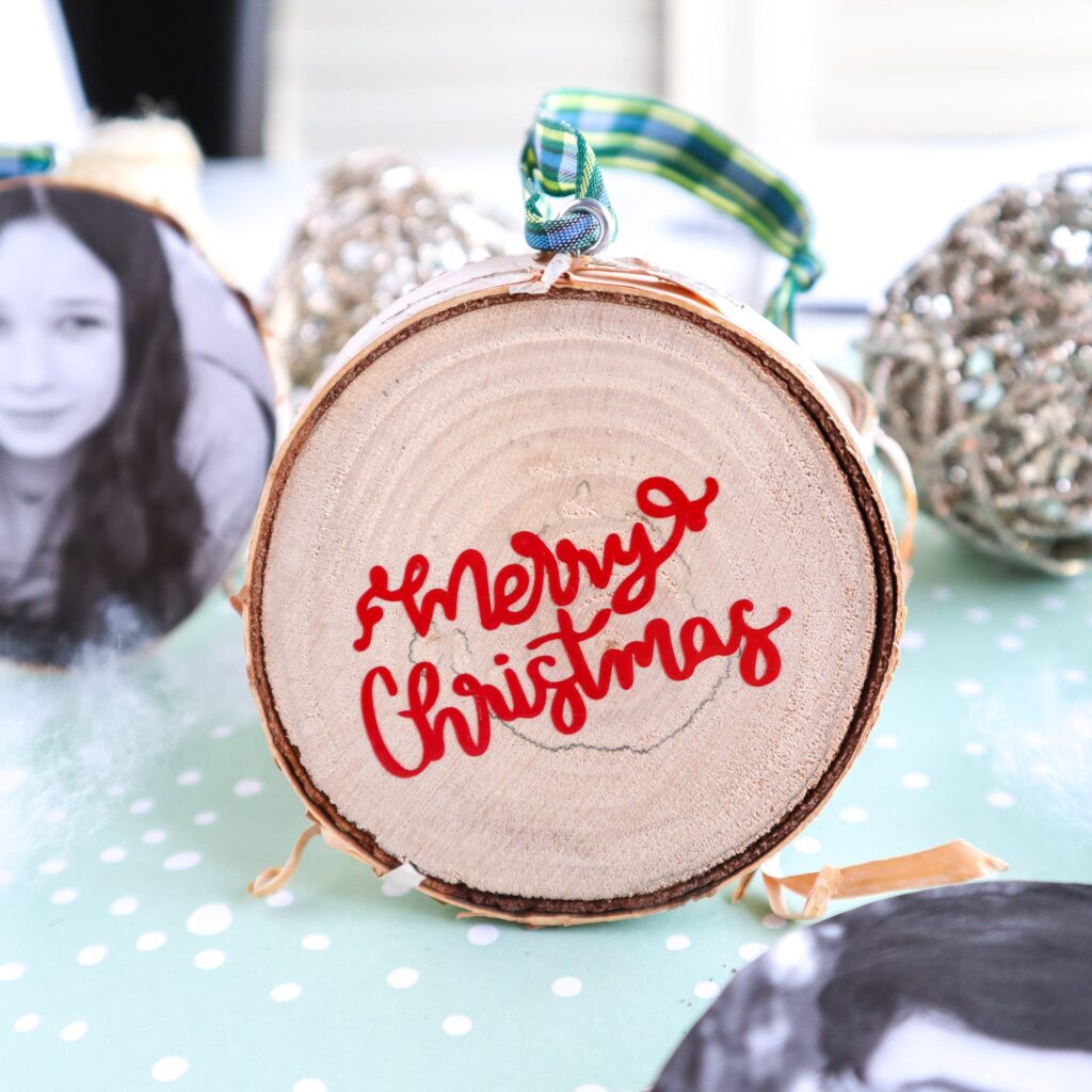 Close up of DIY wood slice Christmas ornament using vinyl for messages.