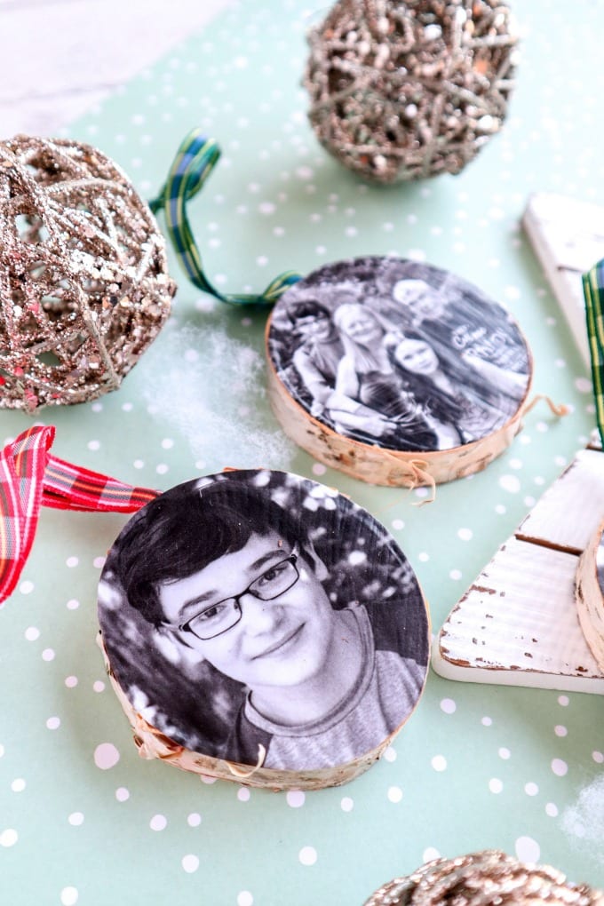 Wood Photo Ornament Craft  - closeup of wood slice ornaments with ribbons that have photographs attached with mod podge.
